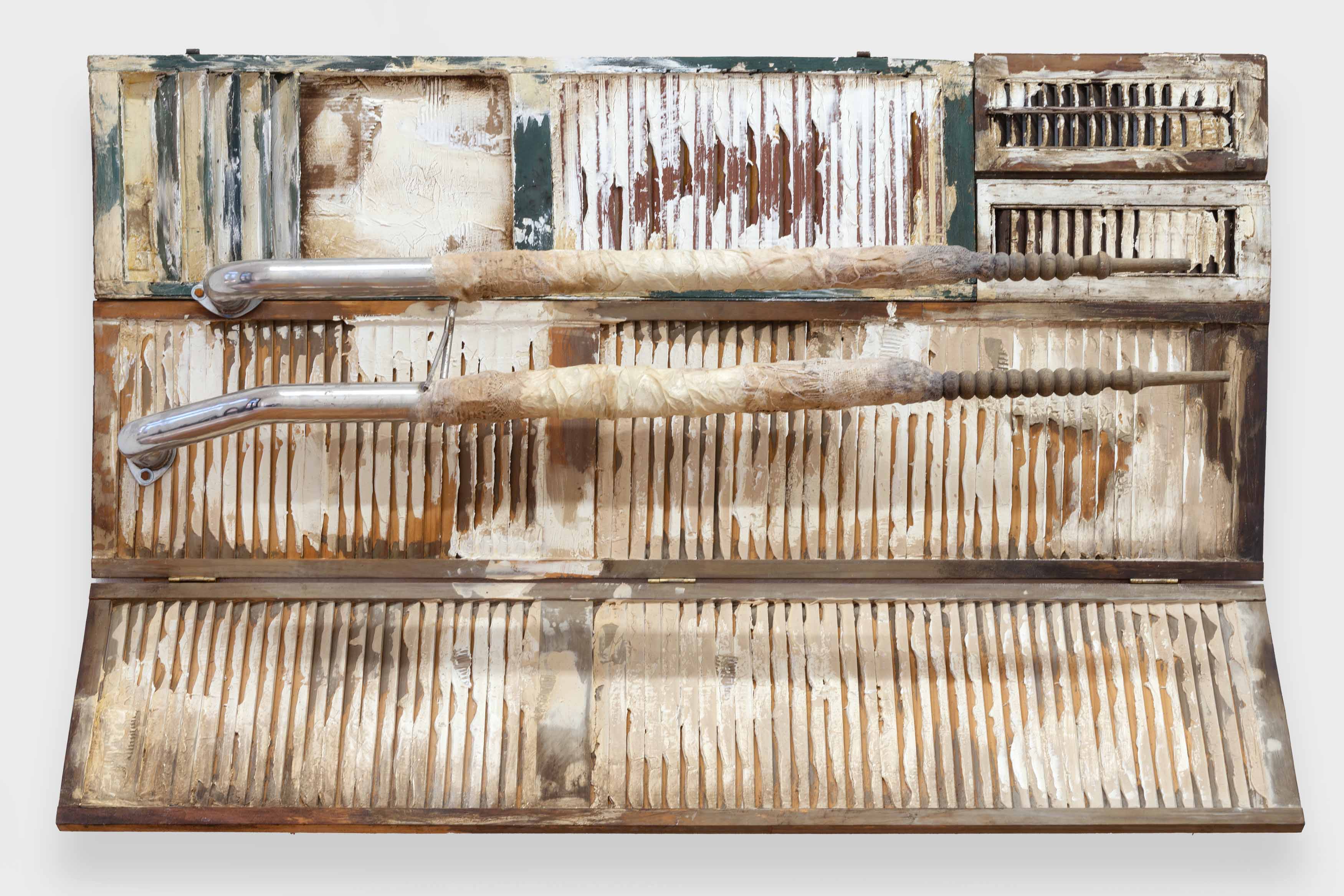 Mónica Mays, <i>tarring and feathering</i>, 2026. Found wood shutters, found exhaust pipes, vellum, wax, gesso, stain, 50 x 75 1/2 x 17 in (127 x 191.5 x 43 cm)
